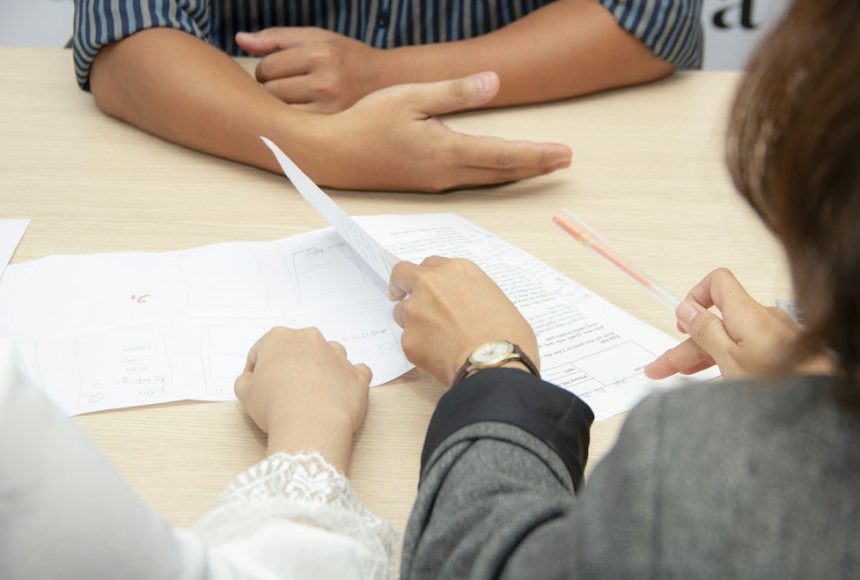 HR specialists reviewing candidate documents in an interview